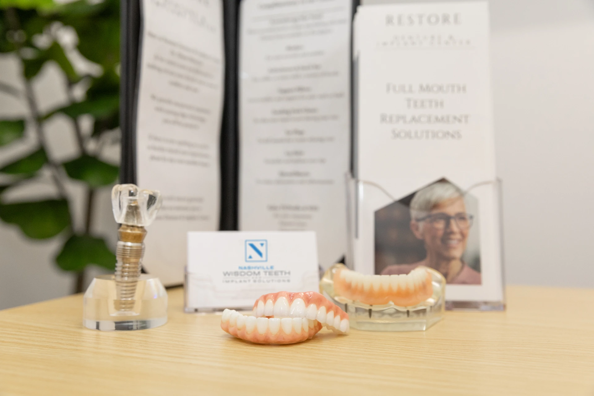 Dental implant options displayed on table. Explore the cost of dental implants in CITY at PRACTICENAME